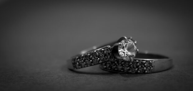 A close up of a wedding ring with a sparkling diamond and detailed band, 2K Desktop Wallpaper