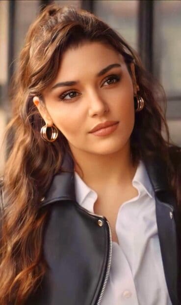 A close up shot of Hande Ercel with wavy hair and golden hoop earrings looking serene, HD Phone Wallpaper