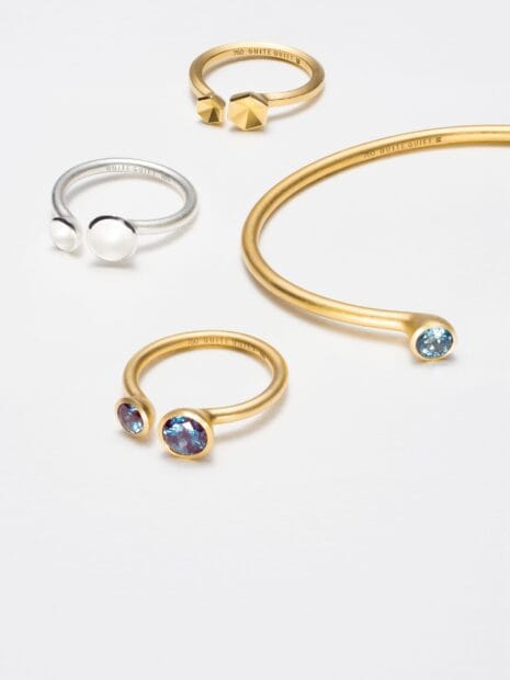A collection of gold and silver rings with blue and clear gemstones displayed on a white surface, HD Desktop Wallpaper