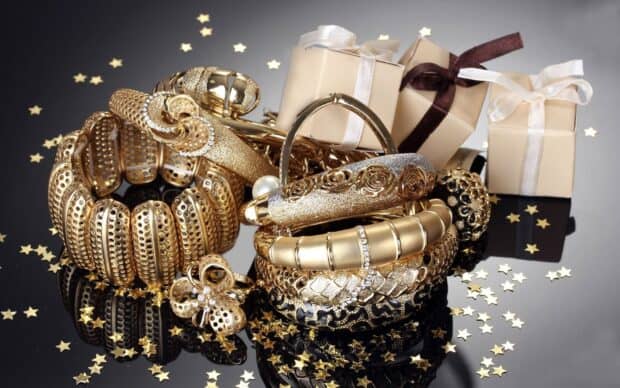 A collection of elegant gold jewelry pieces with decorative gift boxes and star shaped confetti, HD Desktop Wallpaper