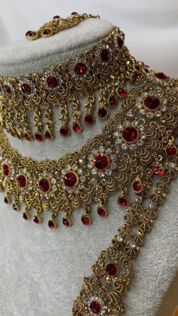 A close up of intricate gold jewelry featuring red gemstones and detailed designs, 4K Mobile Wallpaper