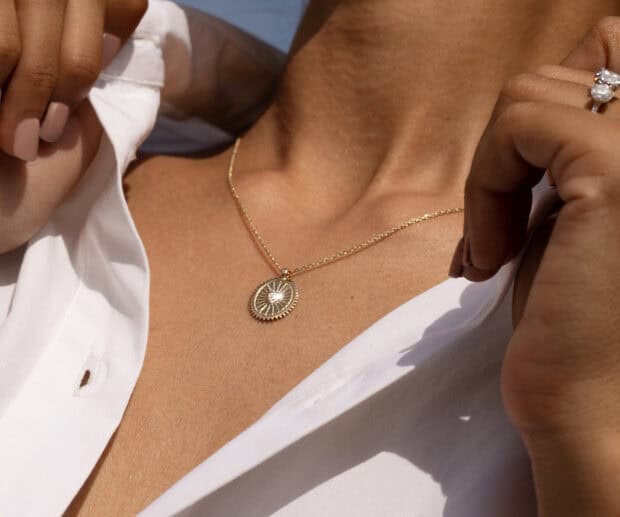 A close up view of a jewelry necklace and ring on a woman wearing a white shirt, HD Mobile Wallpaper