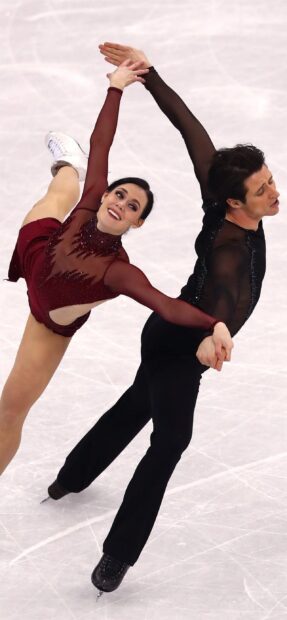 A female skater in burgundy outfit and a male skater in black attire g~ncing pairs in a graceful pose on the rink, showcasing their skill and coordination during a performance. 2K Mobile Wallpaper