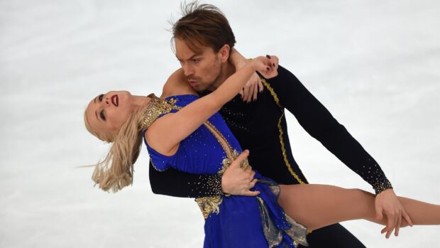 A male and female skater perform an elegant ice dancing routine in vibrant costumes, 2K Desktop Wallpaper