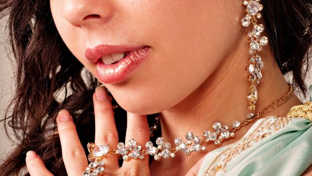 A woman wears elegant jewelry with sparkling crystals and gold details, HD Desktop Wallpaper
