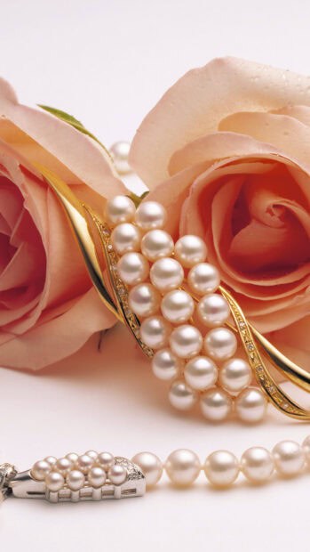 A close up of pearl jewelry placed beside pink roses showcasing intricate details, HD Mobile Wallpaper