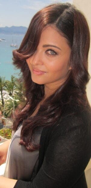 Aishwarya Rai smiles softly near the sea with curled hair, 2K Mobile Wallpaper