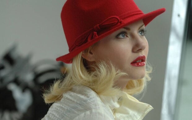 A close up of Elisha Cuthbert wearing a red hat and white coat looking thoughtfully, HD Desktop Wallpaper