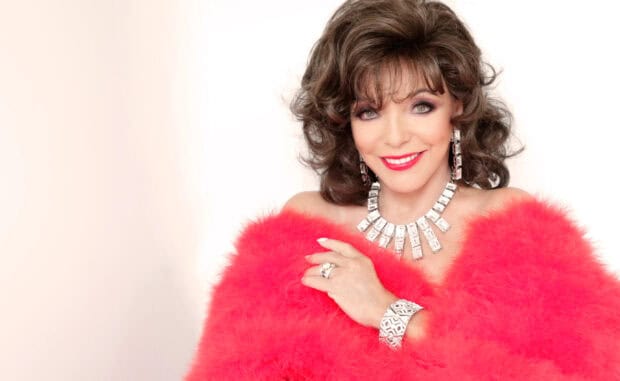 Joan Collins smiles wearing a red feathered outfit and sparkling jewelry, 2K Desktop Wallpaper