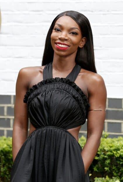 Michaela Coel wears a black dress with a bright smile outdoors, HD Mobile Wallpaper