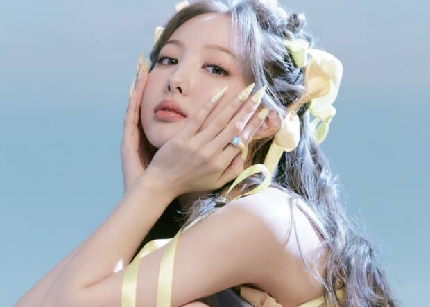 A close up of Nayeon shows her delicate features and yellow hair ribbons, 2K Desktop Wallpaper