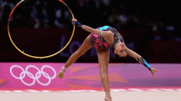 A rhythmic gymnast performs a balance move with a hoop at the Olympics, 4K Desktop Wallpaper