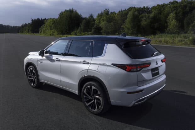 A silver Mitsubishi Outlander is parked on an empty road surrounded by greenery, HD Desktop Wallpaper