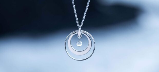 A silver necklace with circular pendants and a small crystal hanging, HD Desktop Wallpaper