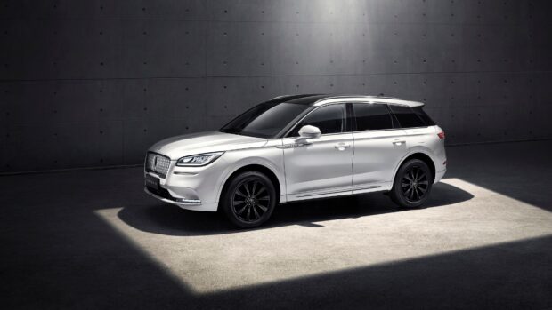 A white Lincoln car is displayed in a minimalist dark showroom with light highlighting it, 4K Desktop Wallpaper