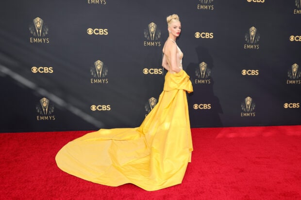 A woman in an elegant yellow gown poses on the red carpet during the Emmy Awards event, HD Desktop Wallpaper