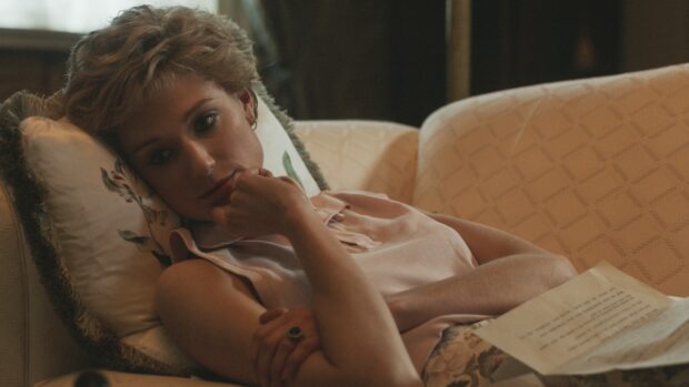 A close up of Elizabeth Debicki resting on a couch with a paper in hand, HD Desktop Wallpaper