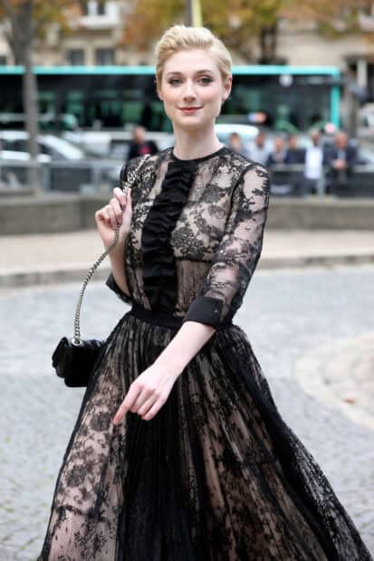 Elizabeth Debicki wears a sheer black lace dress while walking outdoors confidently, HD Mobile Wallpaper