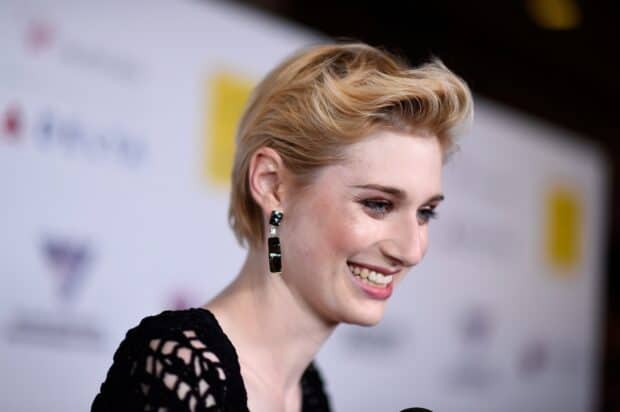 Elizabeth Debicki is smiling while wearing black earrings at an event, HD Desktop Wallpaper
