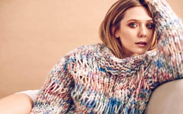 Elizabeth Olsen looks thoughtfully into the camera wearing a vibrant knitted sweater, 2K Desktop Wallpaper