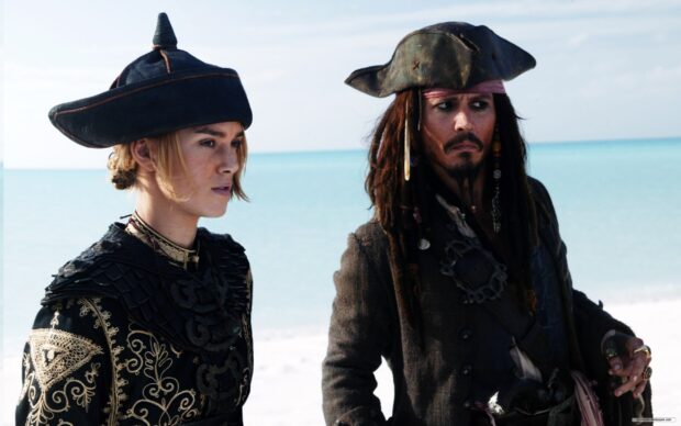 Elizabeth Swann and Jack Sparrow stand near the ocean in detailed pirate attire, 2K Desktop Wallpaper