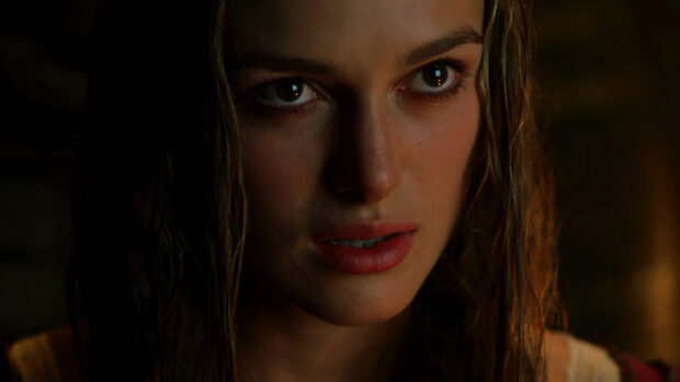 Elizabeth Swann from Pirates Of The Caribbean shows a focused expression in dim light, HD Desktop Wallpaper