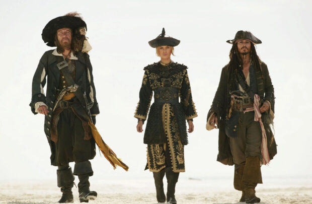 Elizabeth Swann stands confidently with two pirates in elaborate costumes, HD Desktop Wallpaper