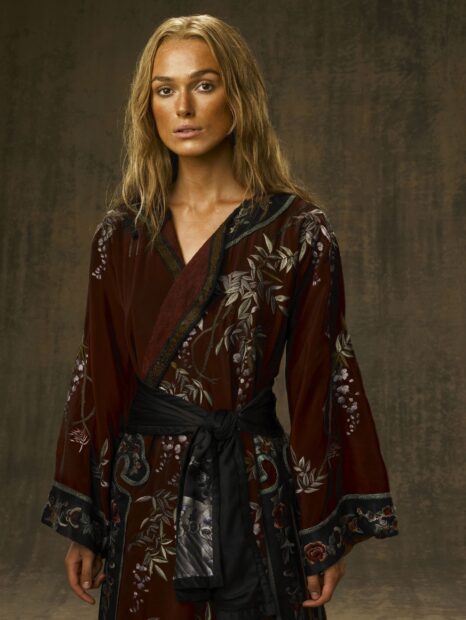Elizabeth Swann wears a maroon embroidered robe with a black sash against a brown backdrop, 2K Desktop Wallpaper