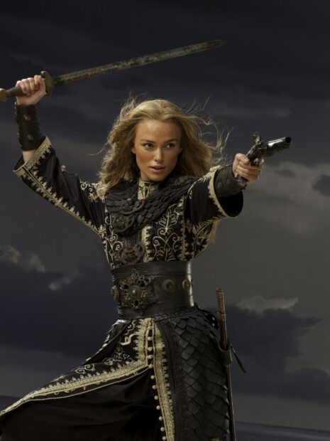 Elizabeth Swann in a detailed black and gold outfit holds a sword and pistol ready for battle, 2K Mobile Wallpaper