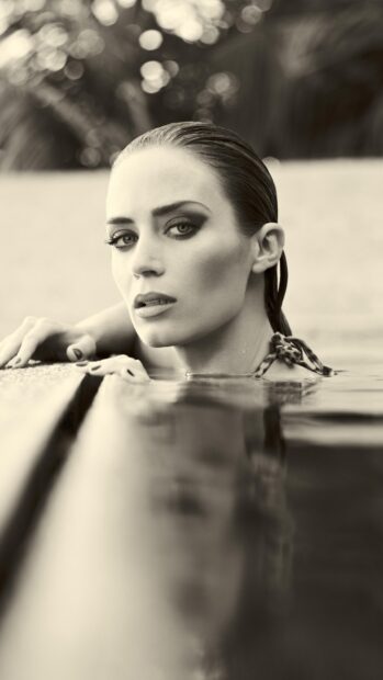 A close up of Emily Blunt resting in a pool with a focused expression, HD Phone Wallpaper