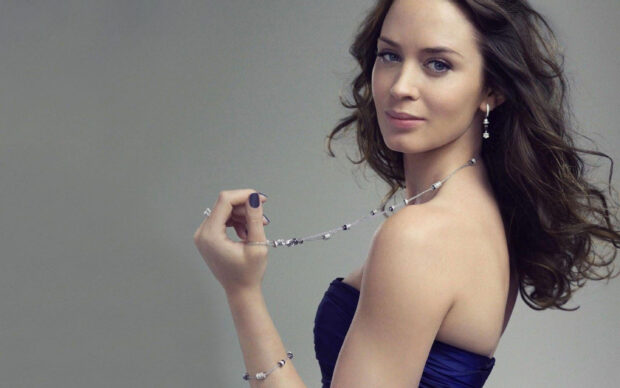 Emily Blunt holds a silver necklace with a calm expression, 2K Desktop Wallpaper