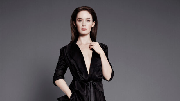 Emily Blunt Wallpapers features her posing confidently in a black outfit with a neutral gray background, HD Desktop Wallpaper