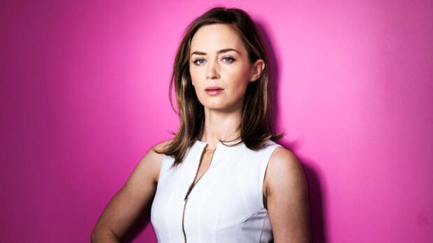 Emily Blunt wallpapers features a woman in a white sleeveless top standing in front of a vibrant pink wall, HD Desktop Wallpaper