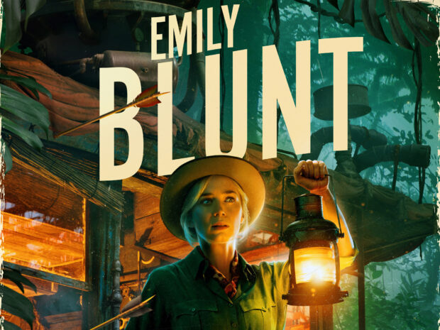 Emily Blunt with a lantern standing in a dense jungle near a wooden cabin, HD Desktop Wallpaper