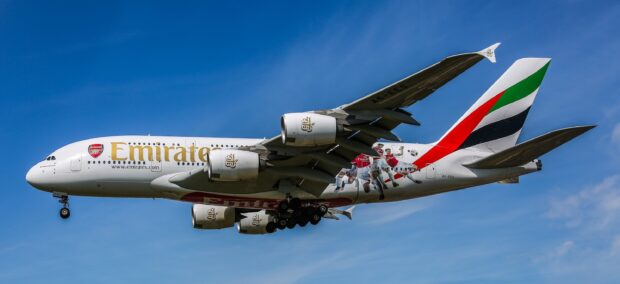 An Emirates Airbus A380 airplane is shown flying against a clear blue sky, 2K Desktop Wallpaper