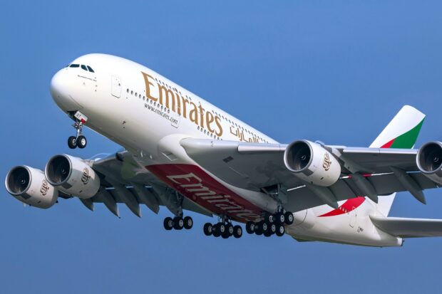 The Airbus A380 from Emirates is captured soaring against a clear blue sky, 2K Desktop Wallpaper