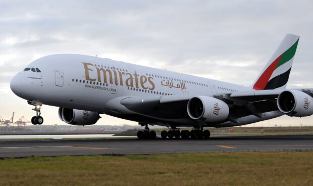 Emirates Airbus A380 is touching down on the runway during a cloudy day, 2K Desktop Wallpaper