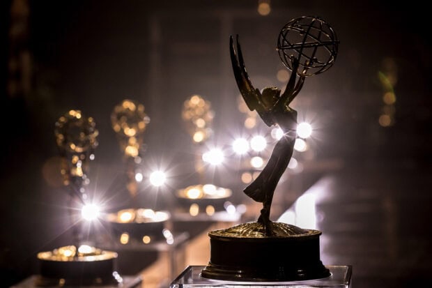 A golden Emmy Awards statuette is illuminated with multiple lights in the background, 2K Desktop Wallpaper