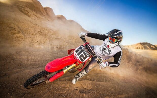 A rider on an enduro motorbike is speeding through a dusty desert track, HD Desktop Wallpaper