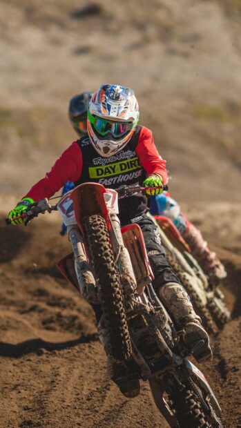 A rider performs a wheelie on an enduro motorbike in a dirt race, HD Mobile Wallpaper