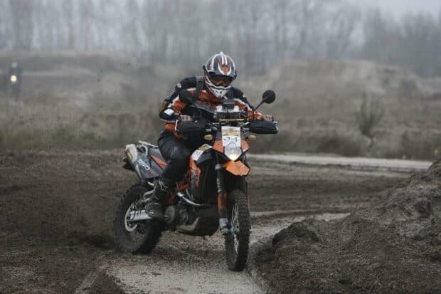 A rider on an enduro motorbike navigating a muddy dirt track in rough terrain, HD Desktop Wallpaper