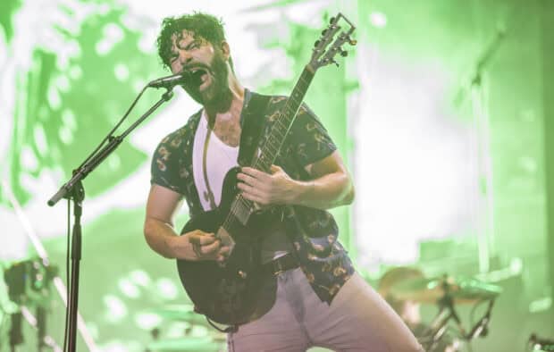 A Foals band member passionately sings and plays guitar during a live concert, HD Desktop Wallpaper