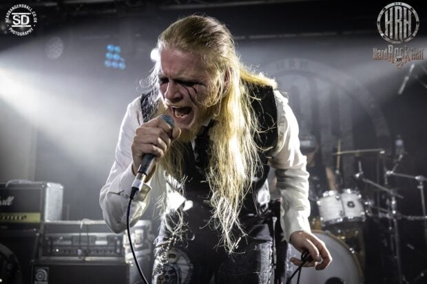 The hard rock singer passionately performs on stage with dramatic lighting and intense expression, HD Desktop Wallpaper