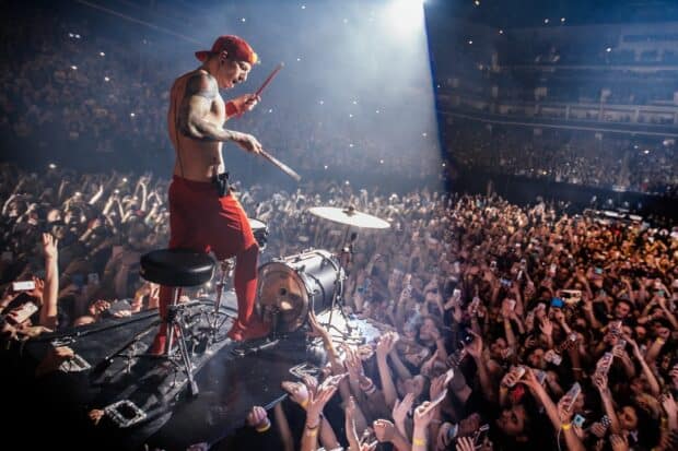 Josh Dun is playing the drums on stage during a live concert with a large crowd, HD Desktop Wallpaper