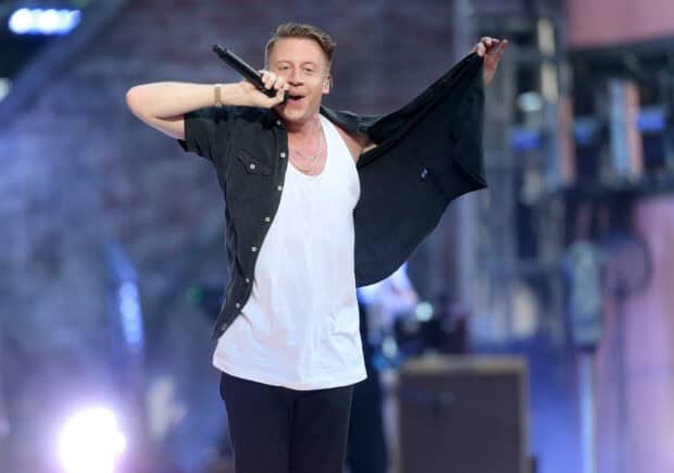 Macklemore is performing live with expressive gestures and singing into a microphone, HD Desktop Wallpaper