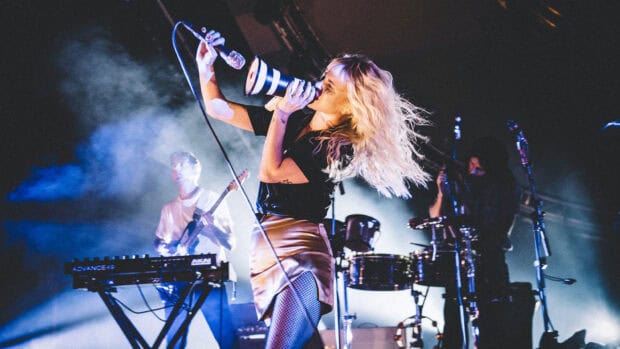 A Paramore live concert scene shows the lead singer passionately performing with band members on stage, HD Desktop Wallpaper