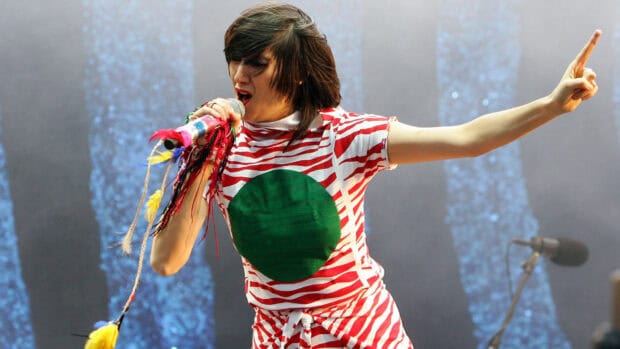 The lead singer of Yeah Yeah Yeahs passionately sings on stage during a live concert, HD Desktop Wallpaper