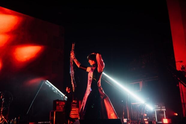 The lead singer of Yeah Yeah Yeahs performs on stage with vibrant lighting, HD Desktop Wallpaper