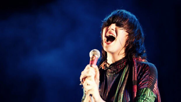 The lead singer passionately performs on stage with a colorful outfit, HD Desktop Wallpaper