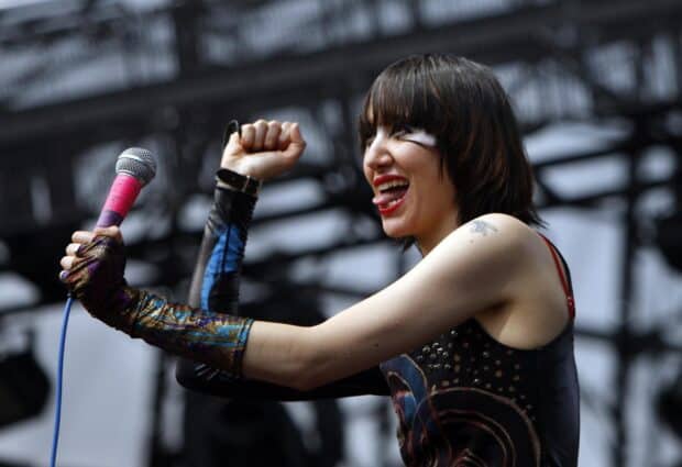 The lead singer of Yeah Yeah Yeahs is passionately singing during a live show, HD Desktop Wallpaper